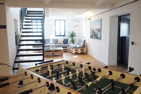 Empfangsbereich bei e-pixler mit einem Kicker und einer Lounge-Ecke im Büro.