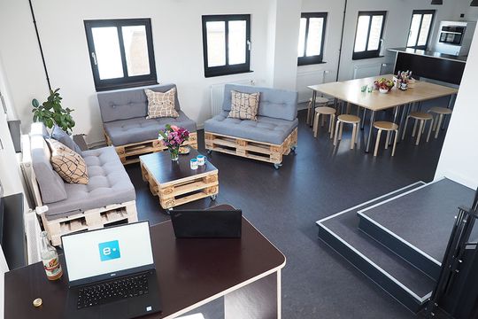 Turmzimmer bei e-pixler mit modernen Möbeln und einem Tisch für Besprechungen.